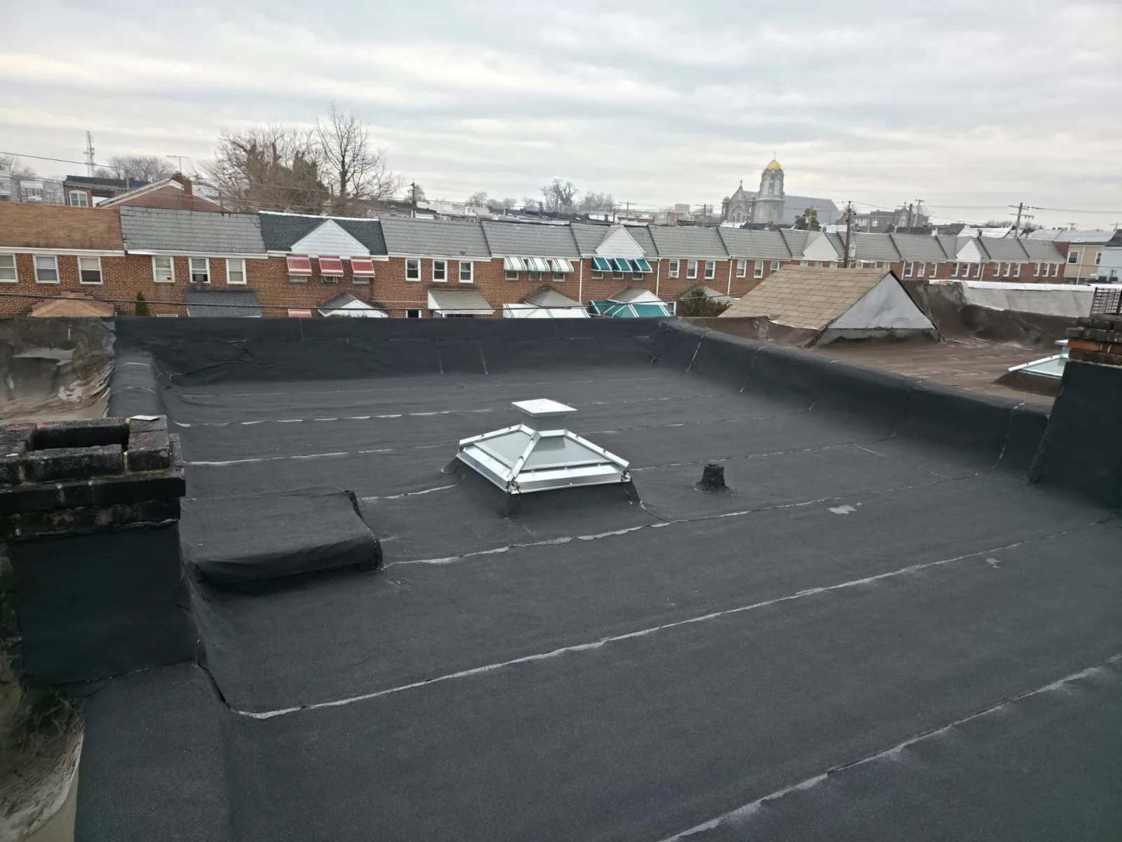 Modified bitumen flat roof replacement with skylight curb on a commercial building