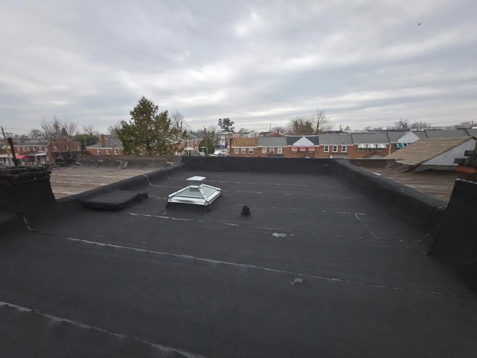 Completed torch-down modified bitumen flat roof replacement, wide view