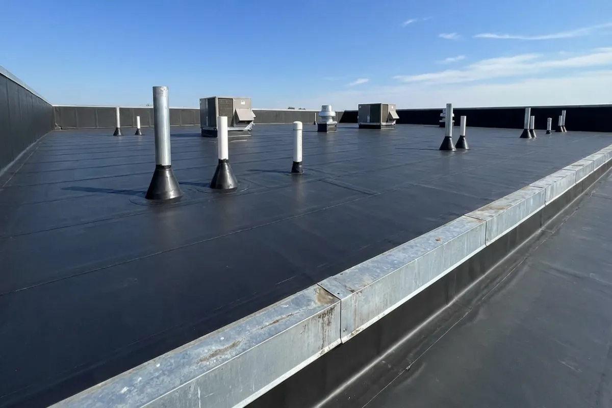 EPDM rubber membrane on commercial flat roof with sealed penetrations