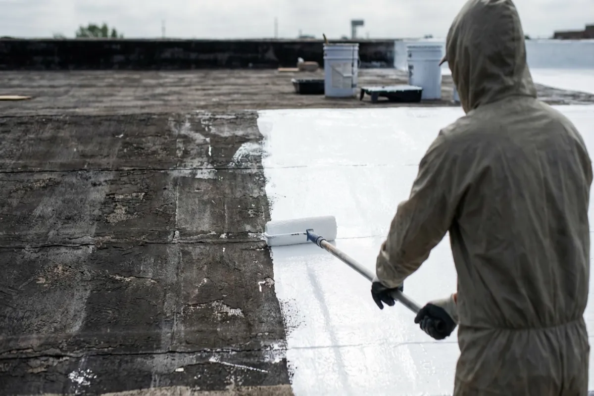 White reflective roof coating application on commercial building