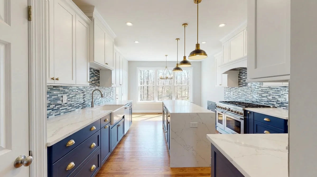 Two-tone kitchen with navy and white cabinets, marble quartz countertops